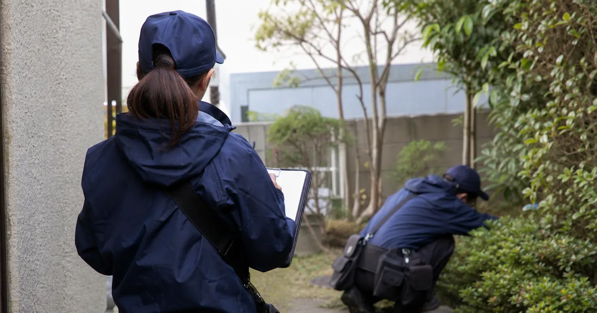 住宅周辺を静かに確認する捜索スタッフ